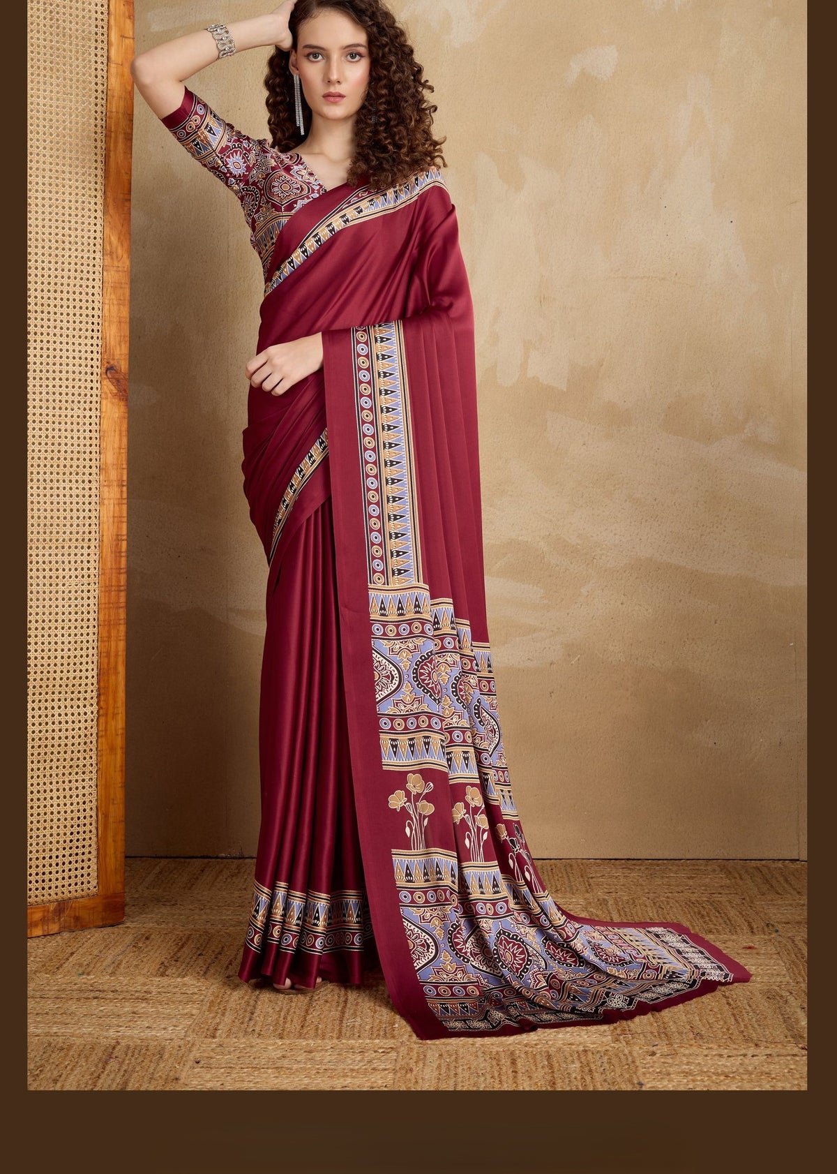 Maroon pure satin saree with Ajrakh motifs in gold, blue and cream; detailed pallu and matching blouse.
