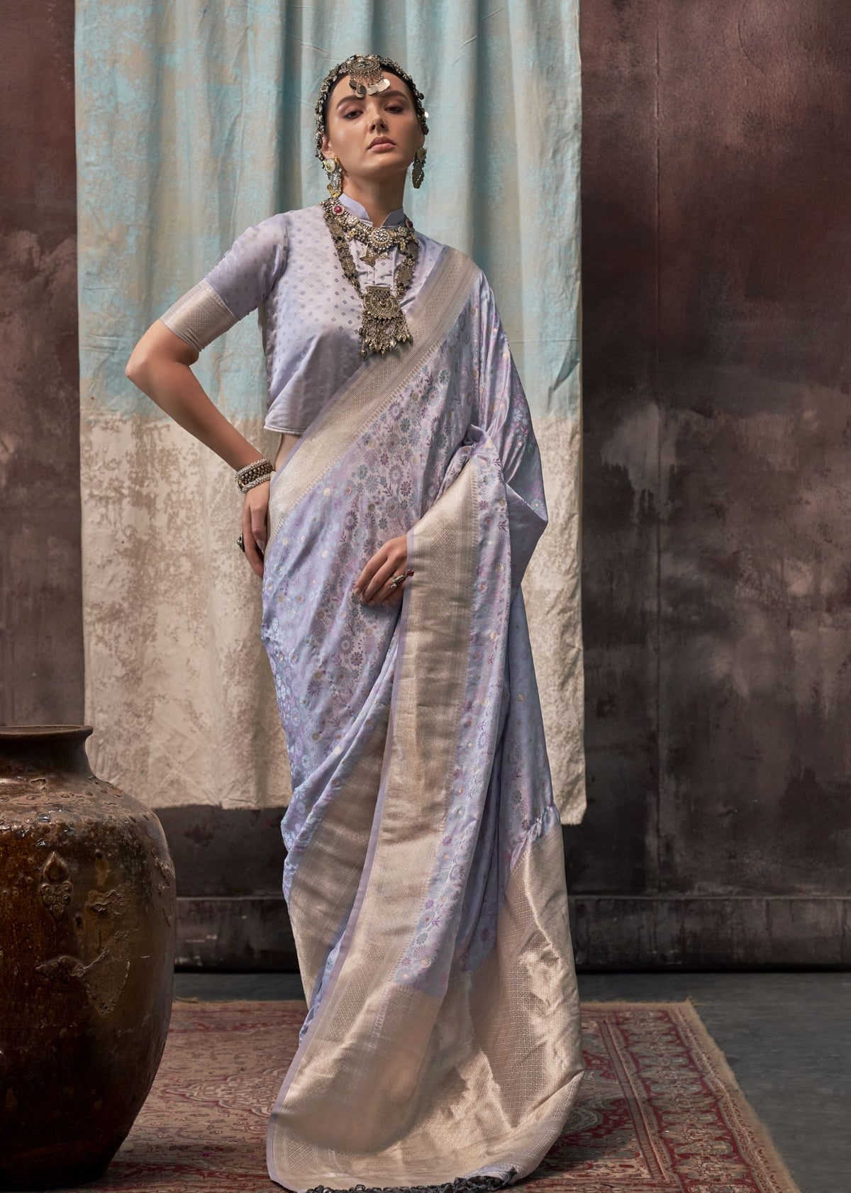 Pink handloom silk saree showcasing detailed woven patterns, paired with a matching short‑sleeved blouse.