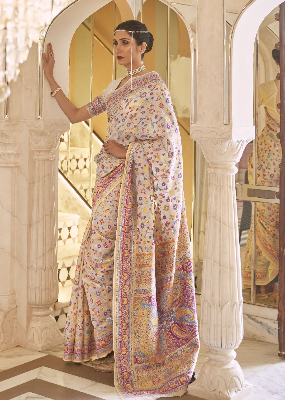 Pastel Kashmiri silk saree with vibrant floral motifs and ornate border, perfect for bridal receptions and traditional Indian fashion shoots.