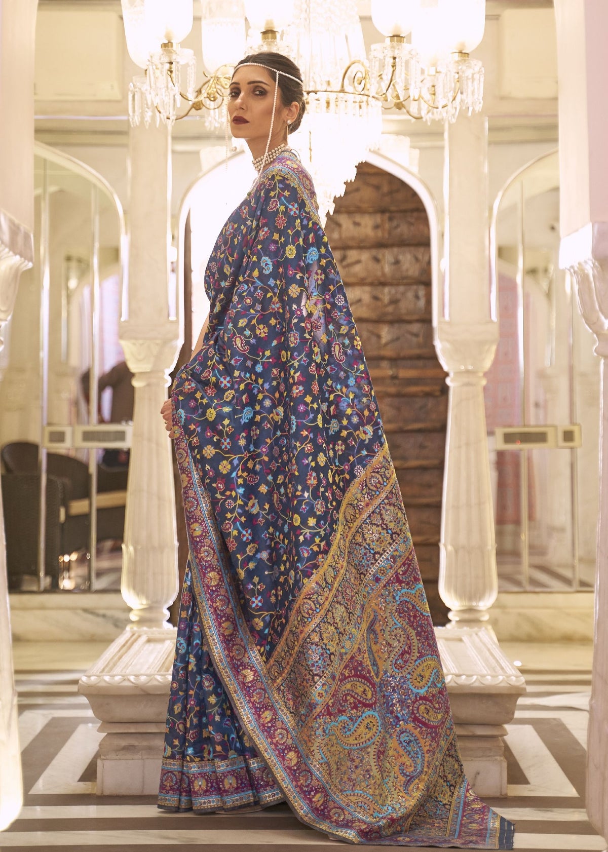 Vibrant Kashmiri silk saree in blue with intricate floral and paisley patterns, perfect for bridal shoots and luxury ethnic fashion campaigns.