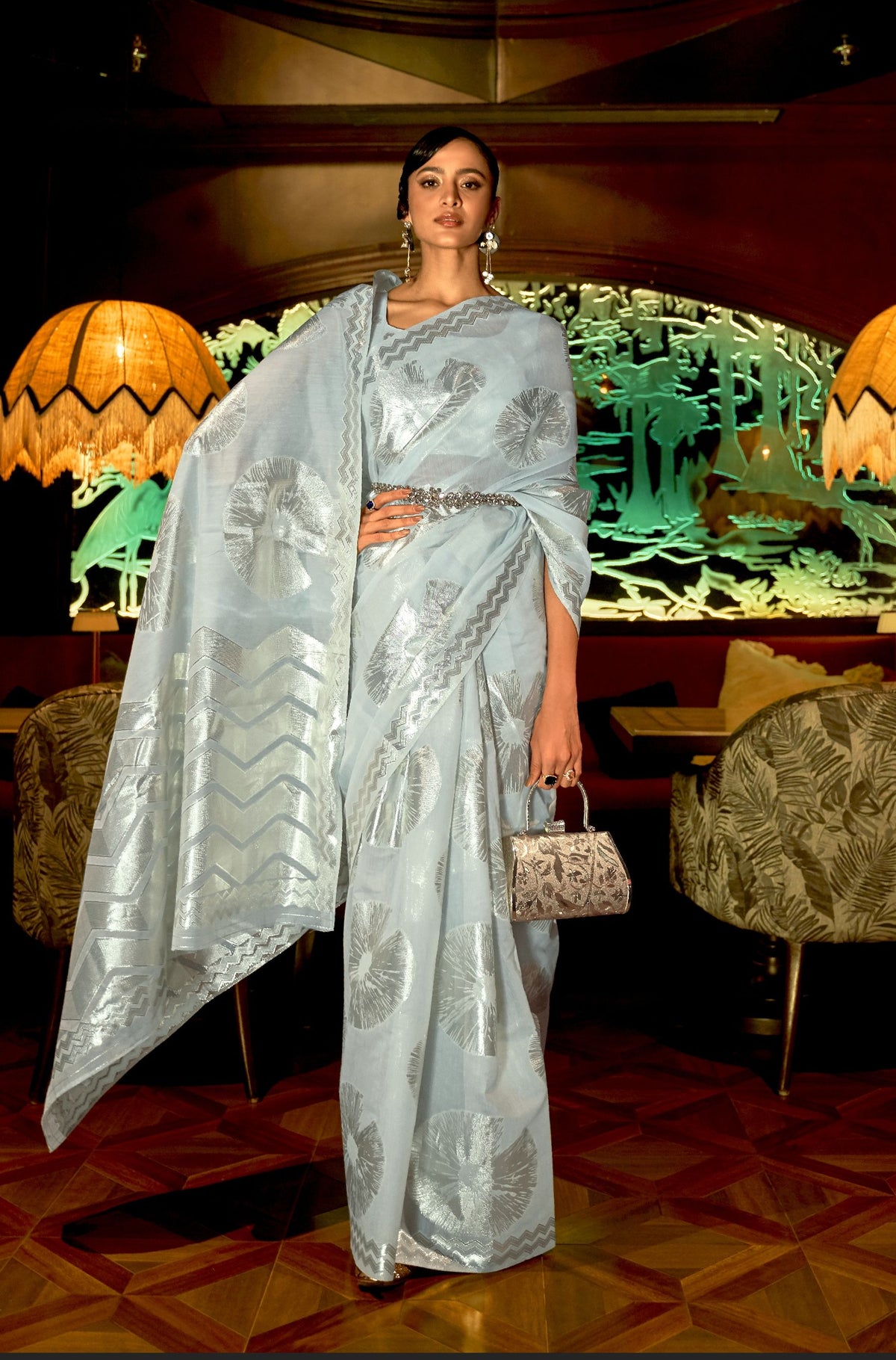 Light blue silk saree with silver motifs and belt styling—cool-toned festive elegance for sangeet and evening wear