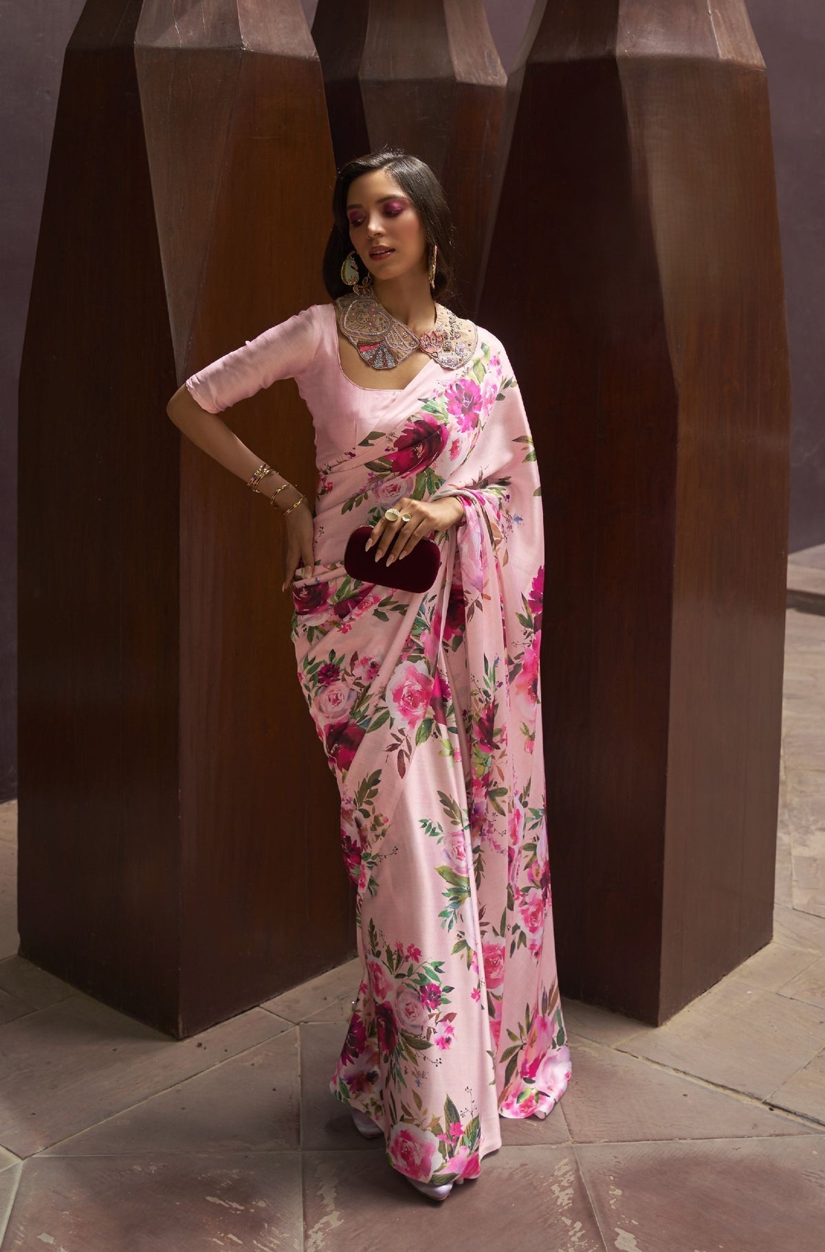 Light pink silk saree with vibrant floral print—green accents and glossy finish for soft festive styling