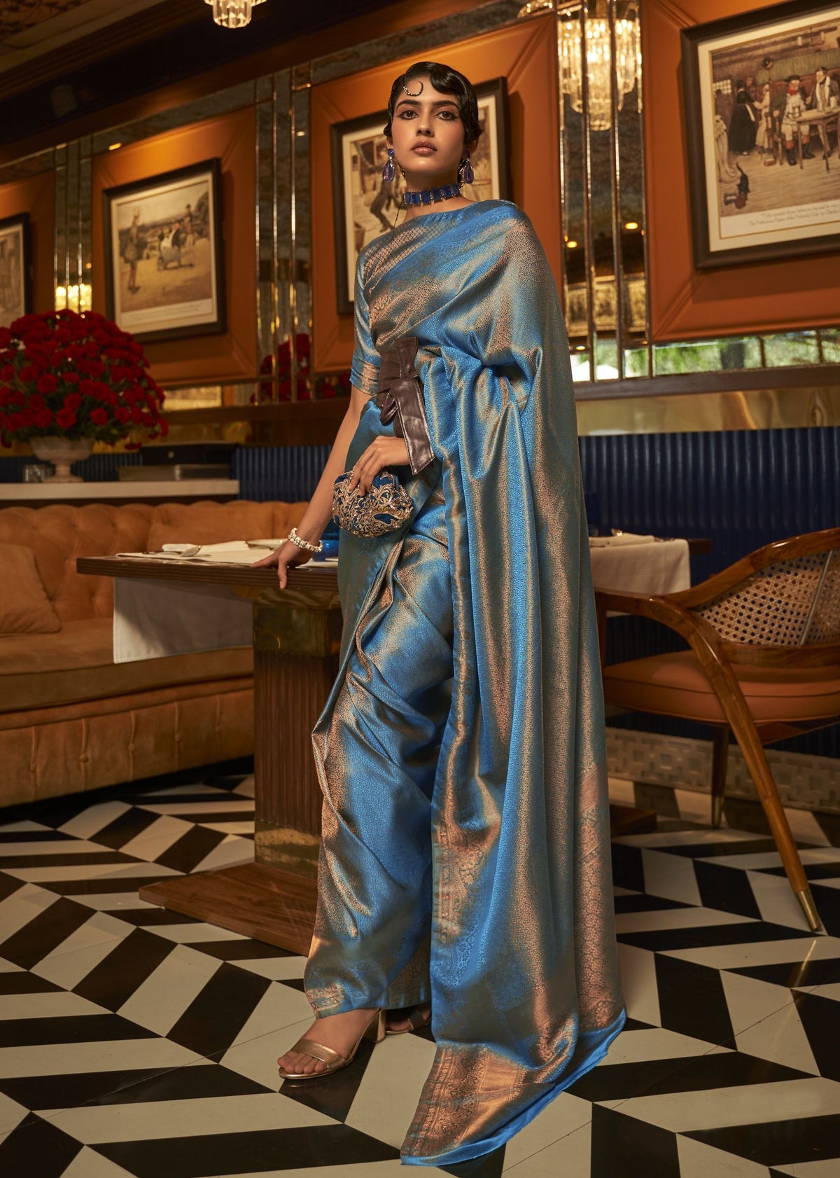 Blue nylon satin copper‑zari saree showcasing a smooth satin shine and ornate copper weaving.