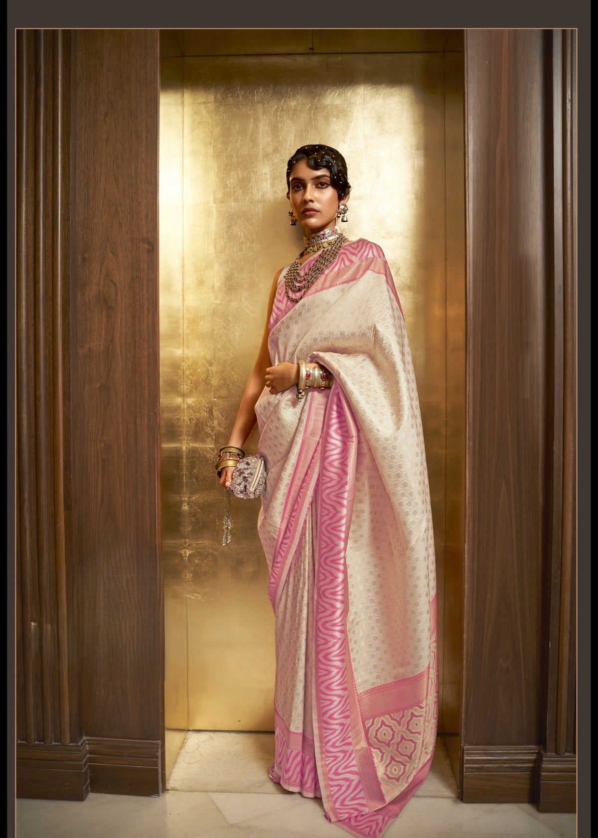 Cream Kazah Silk saree with elegant pink geometric border and woven detailing, soft glossy finish, ideal for premium festive and traditional styling.