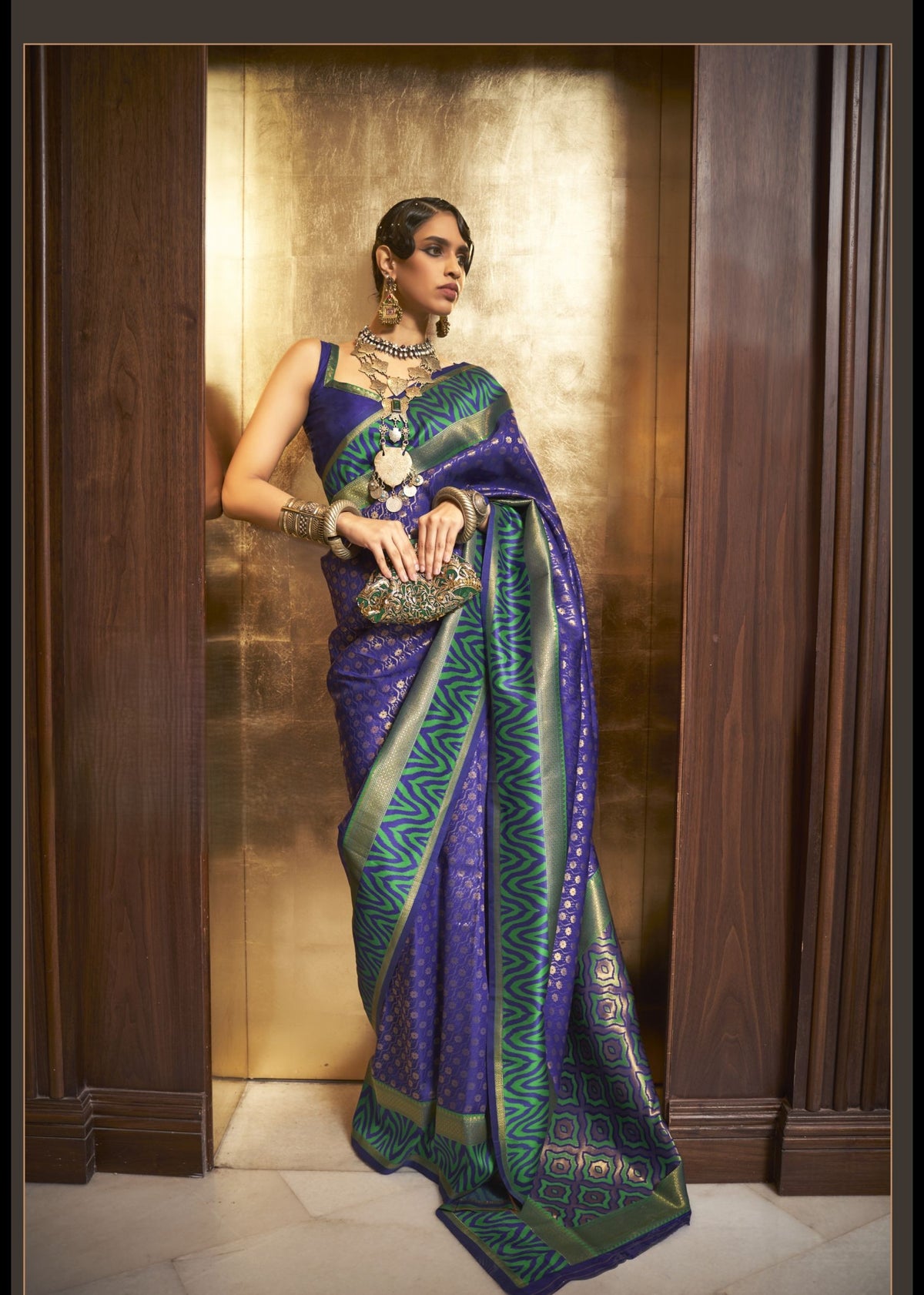 Deep blue Kazah Silk saree with green and gold woven motifs and bold designer border, luxurious silk shine, perfect for weddings and grand celebrations
