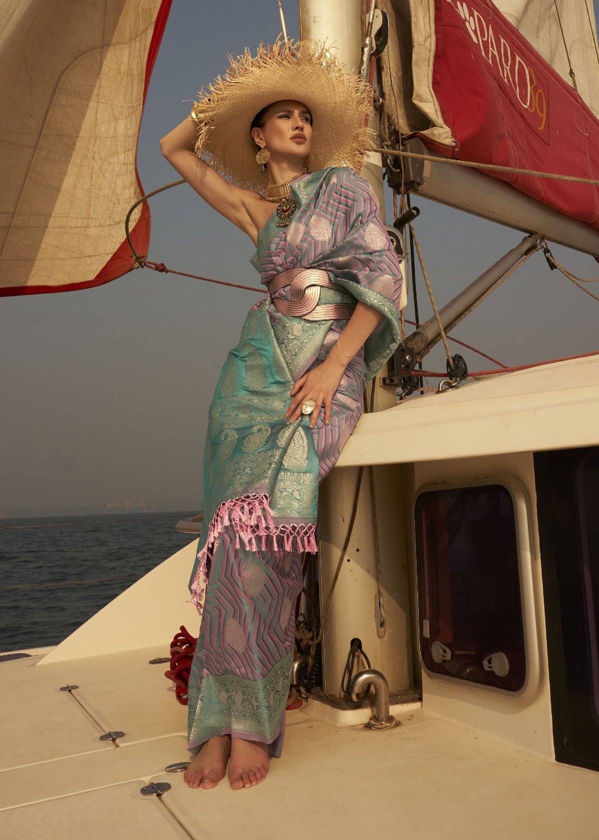 Turquoise and pink lavender saree with metallic motifs and structured belt styling.”