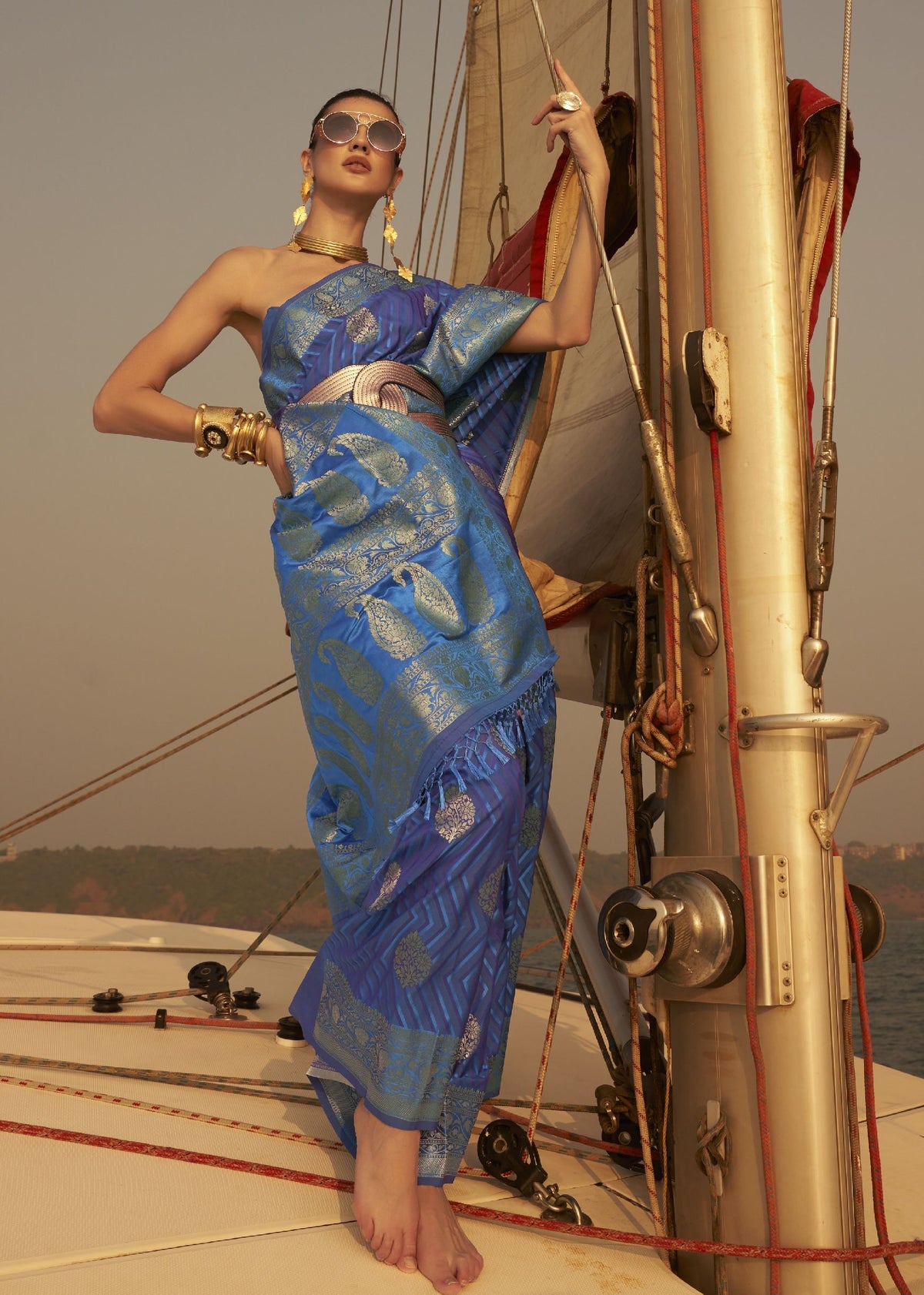 “Blue saree with gold paisley weaving and metallic waist belt.”