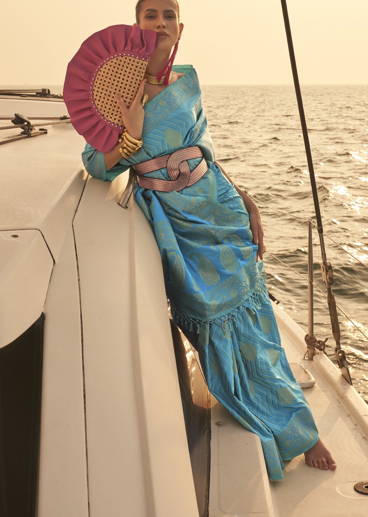 “Blue saree with gold motifs styled with a textured knot belt.”