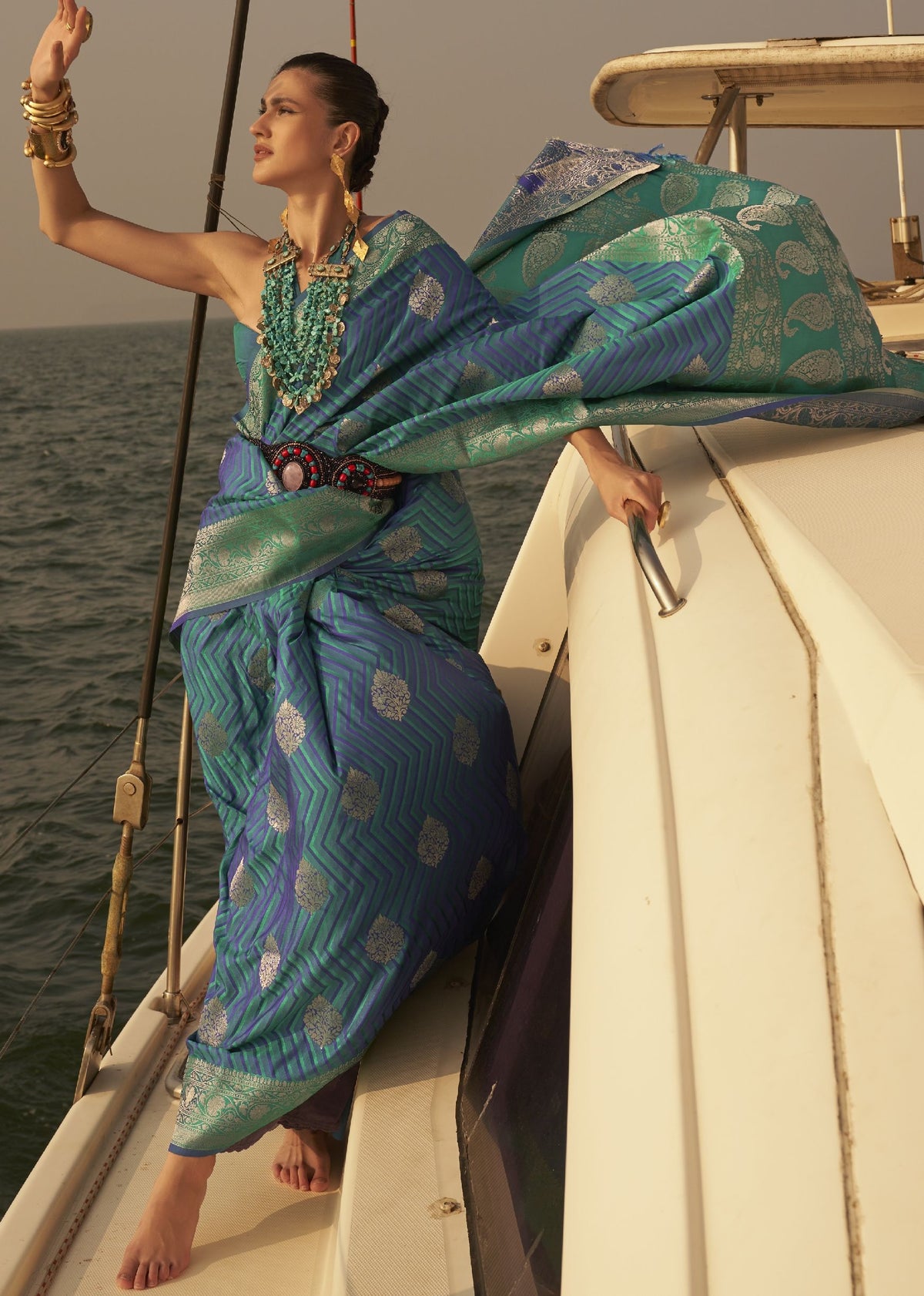 “Blue and green saree with silver chevron weaving and layered jewellery styling.”