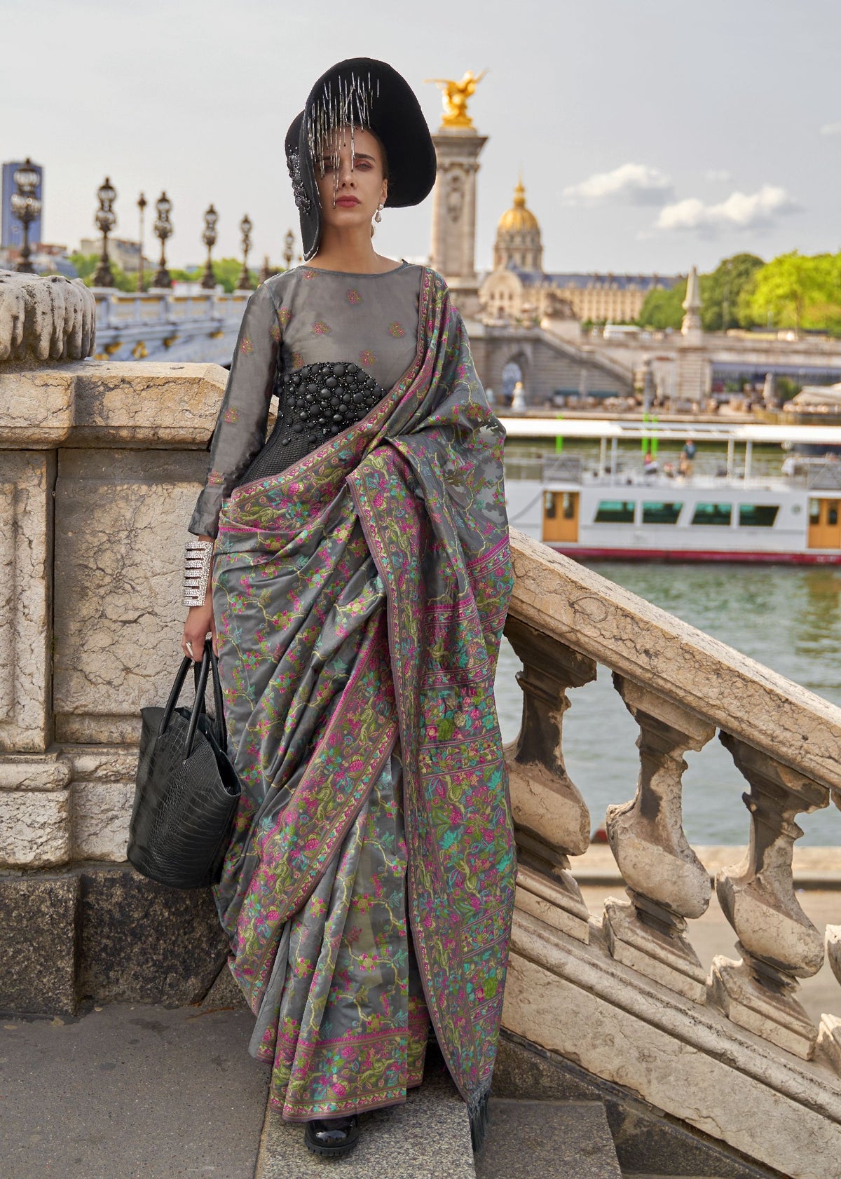 Grey saree with multicolour floral embroidery in pink, green and blue with a detailed woven border.