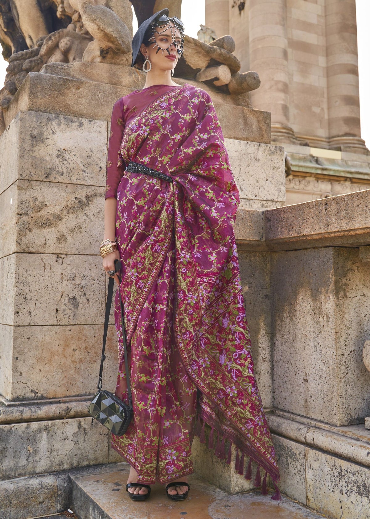Rich magenta saree with green, lavender and gold floral patterns and a premium embroidered border.