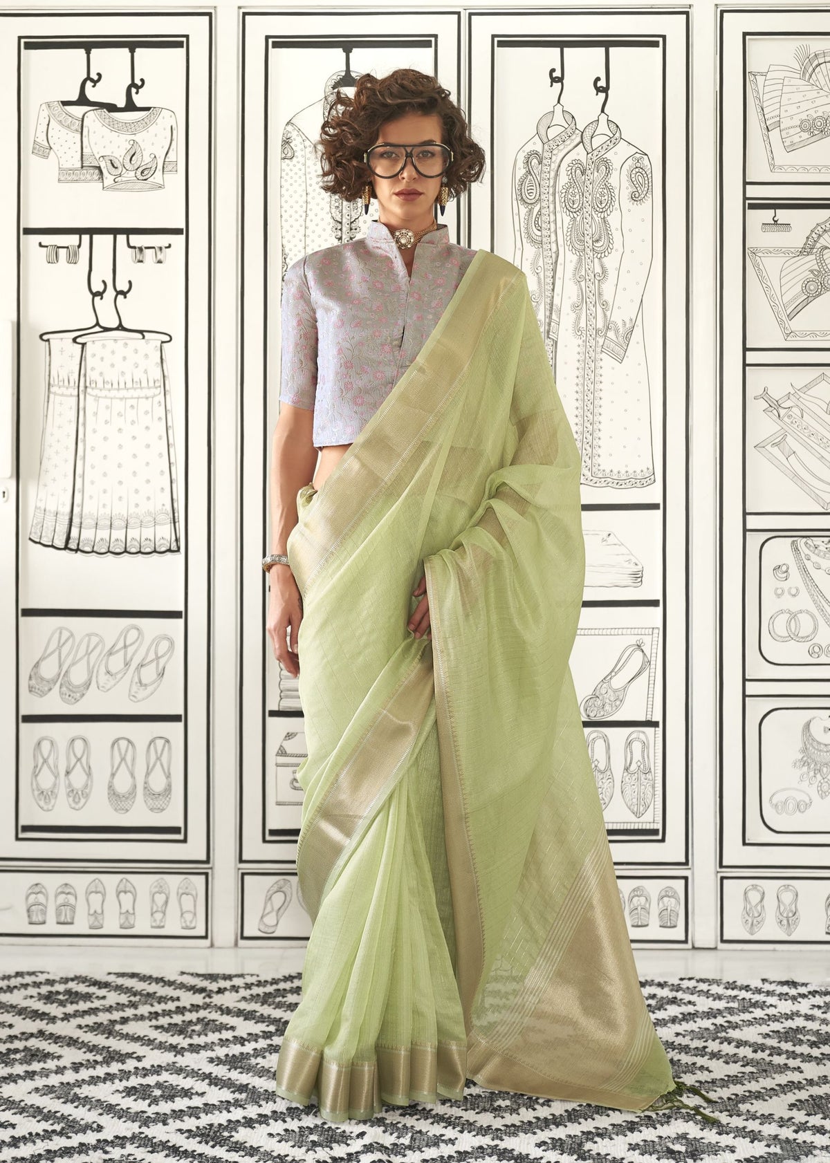 Light green handloom moss chiffon saree with gold edging, matched with a lavender floral embroidered blouse