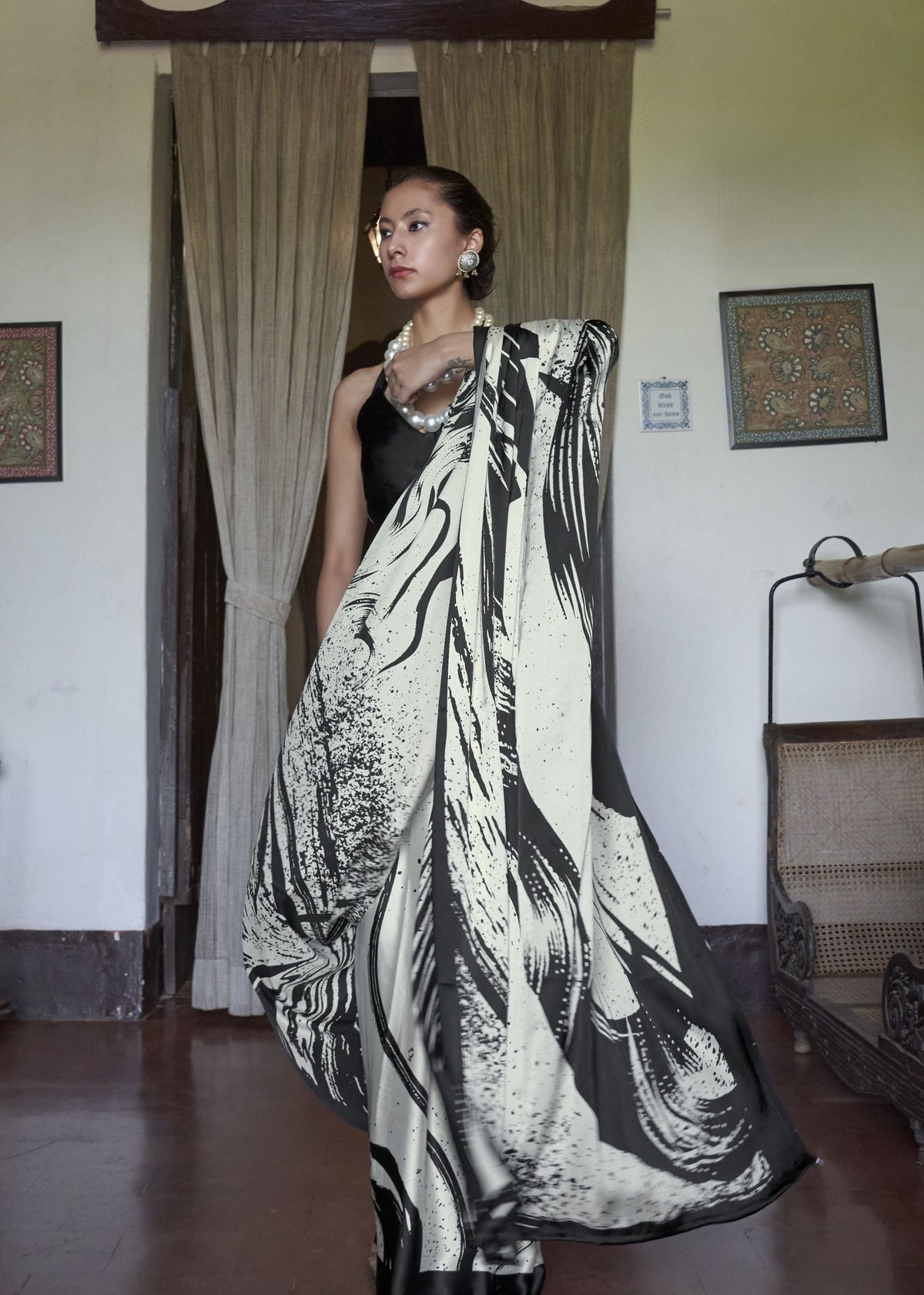 Woman wearing a black and white patterned dress in an indoor setting. Kaalin satin saree - front view