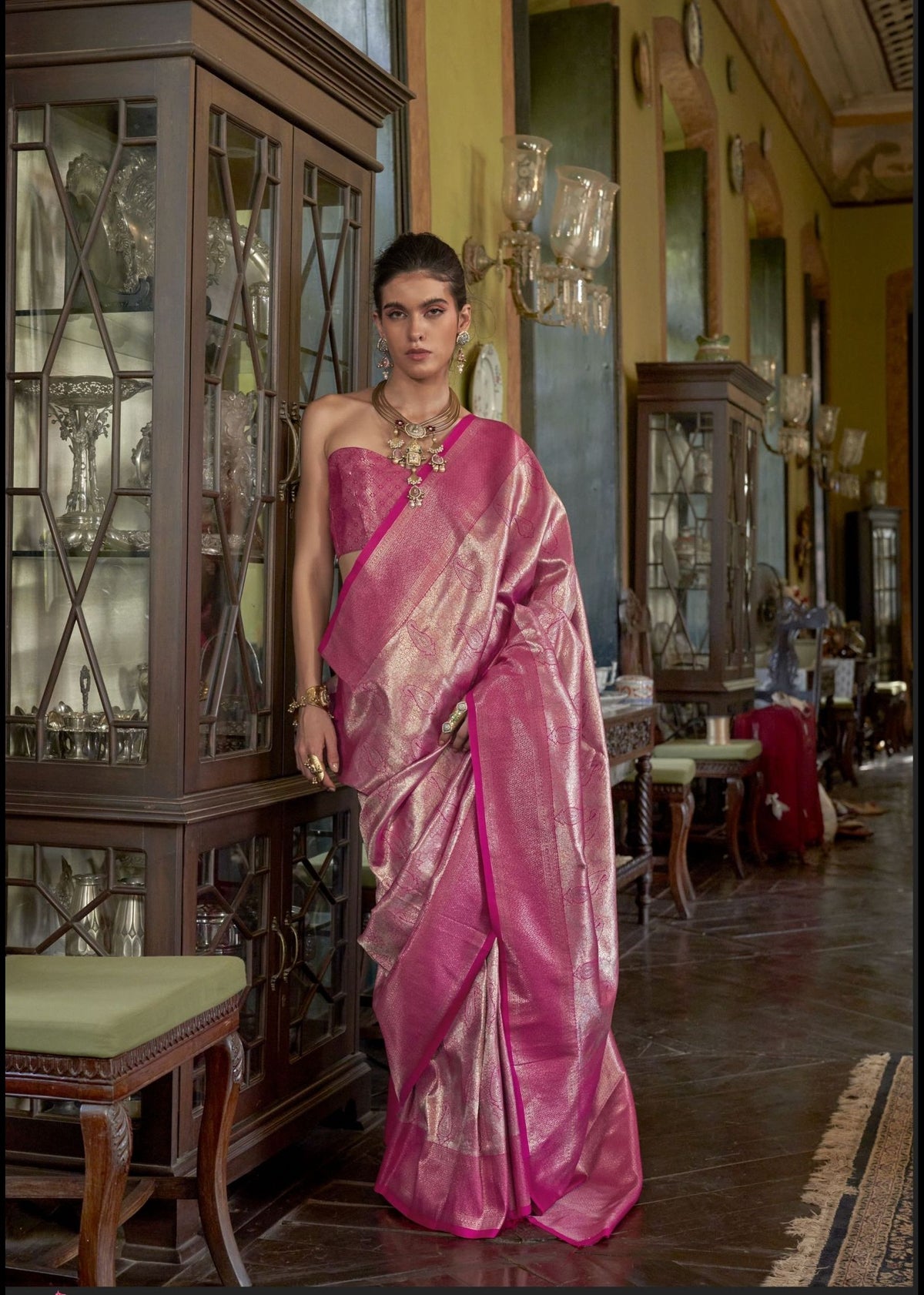 Pink Kanjivaram silk saree with gold zari buttas and a contrasting traditional border in rich gold weave.